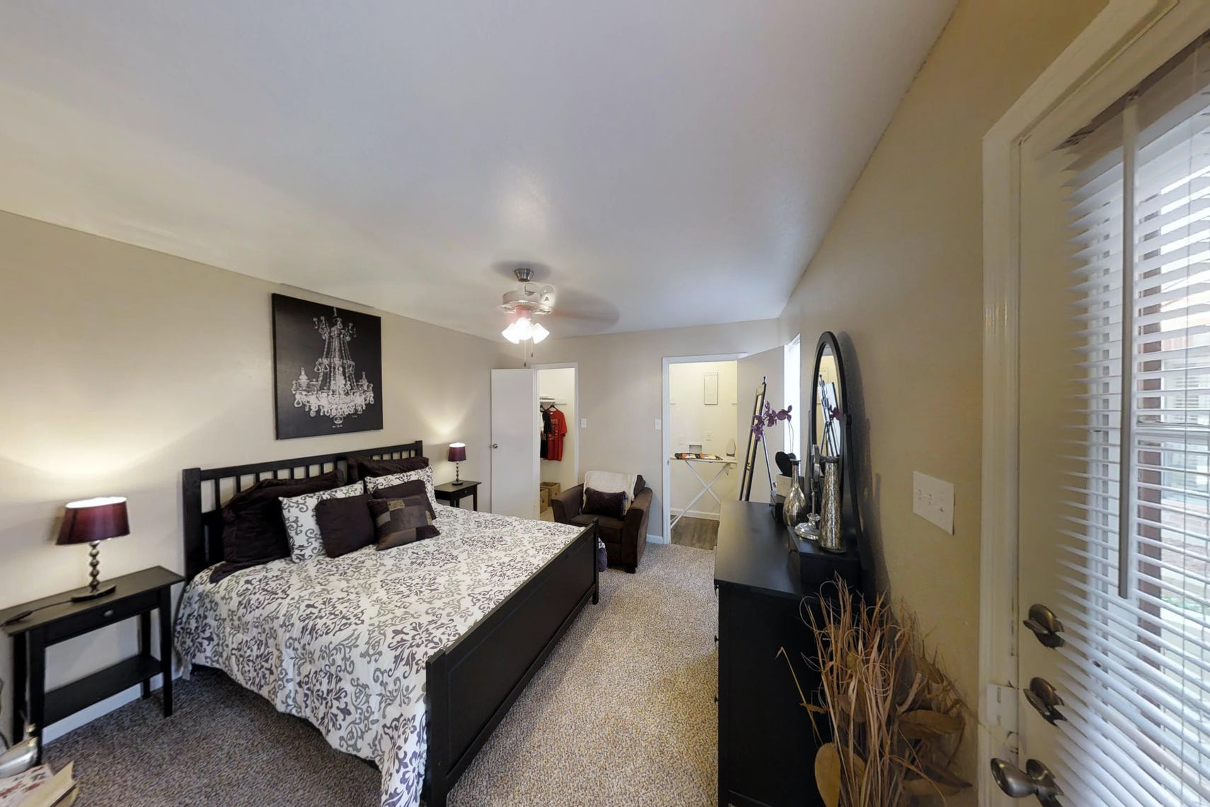 Bedroom at Deerbrook Apartments with two closests, and decorated with a large bed and matching black furniture.