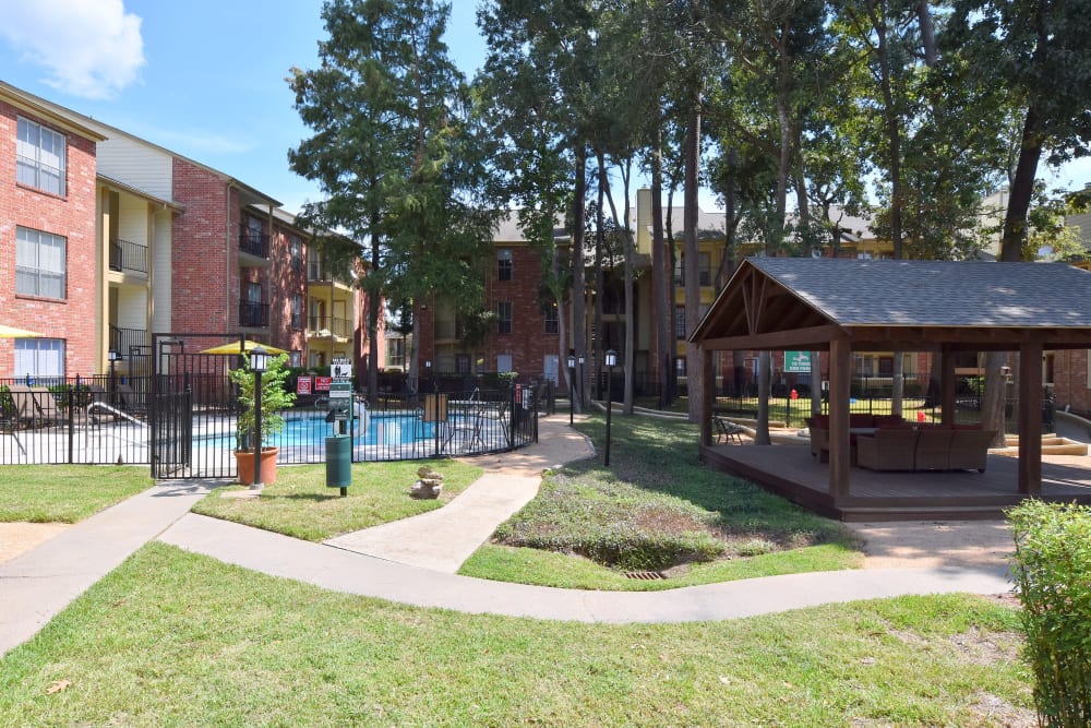 Park at Deerbrook Apartments courtyard with swimming pool and outdoor lounge area with gazebo and couches.