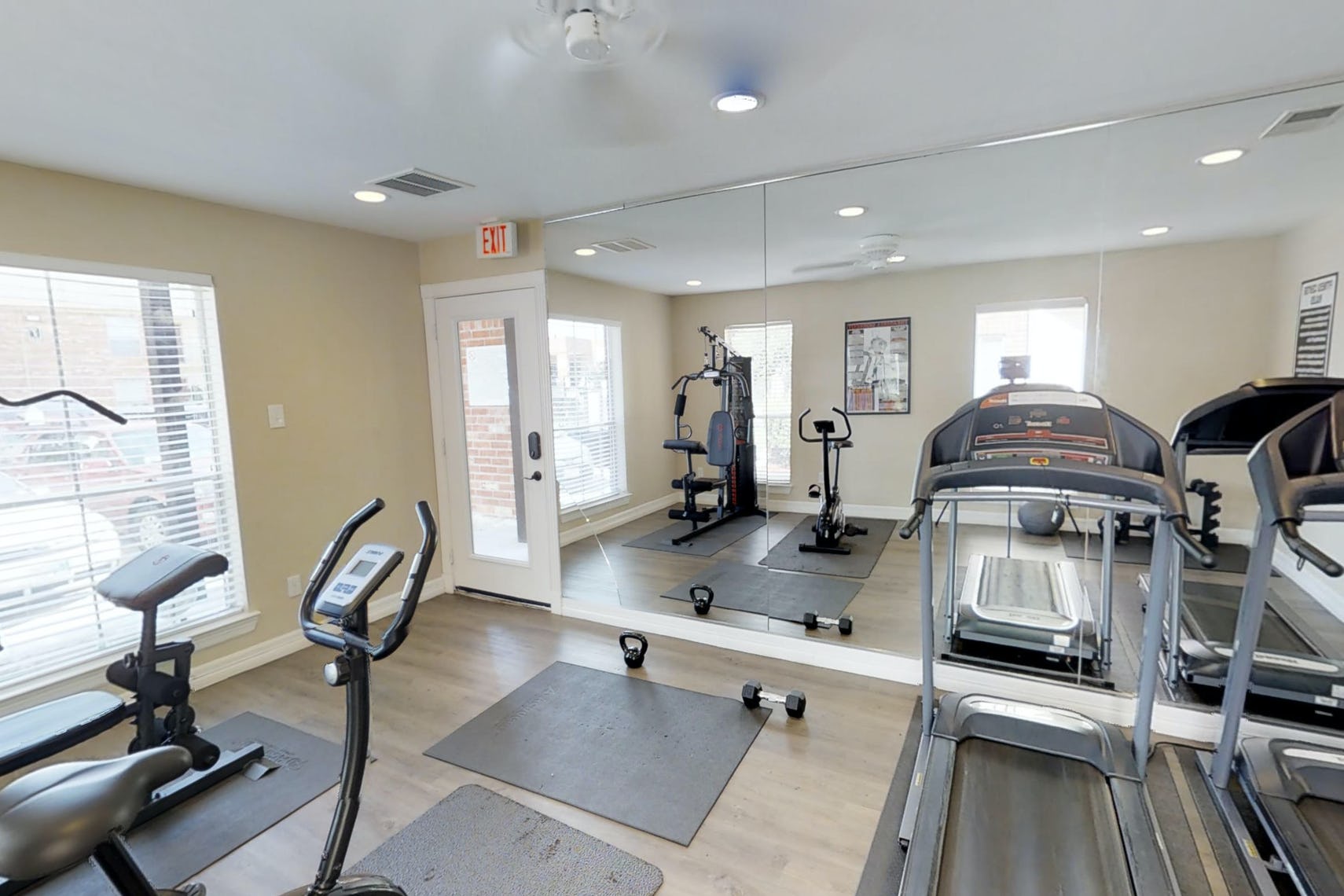 Park at Deerbrook Apartments gym with mirror coving one wall, treadmill, bicycle machine, and weights.