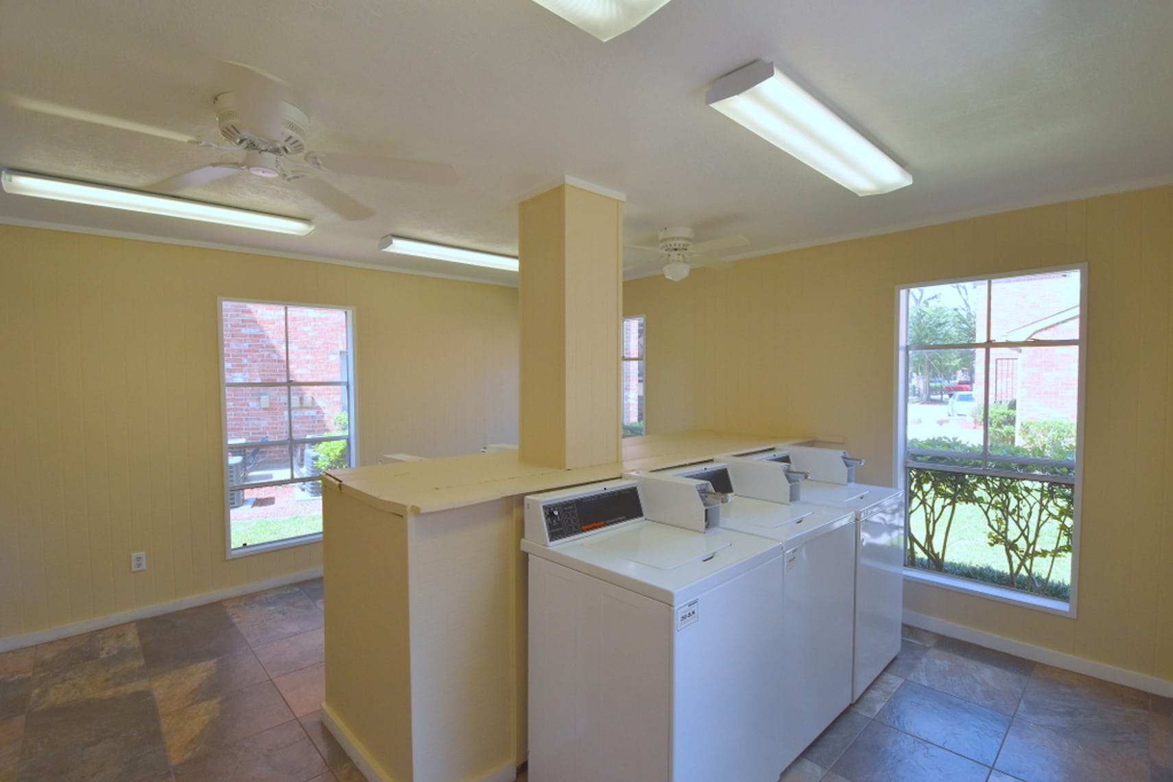 Laundry Room at Deerbrook Apartments. Short wall in dividing the room with machines on either side.