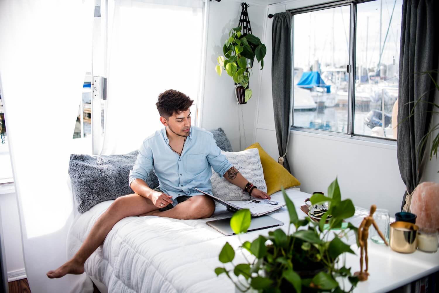 A man on a bed working.