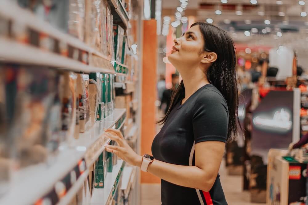 A woman looking at shelves at a store. 